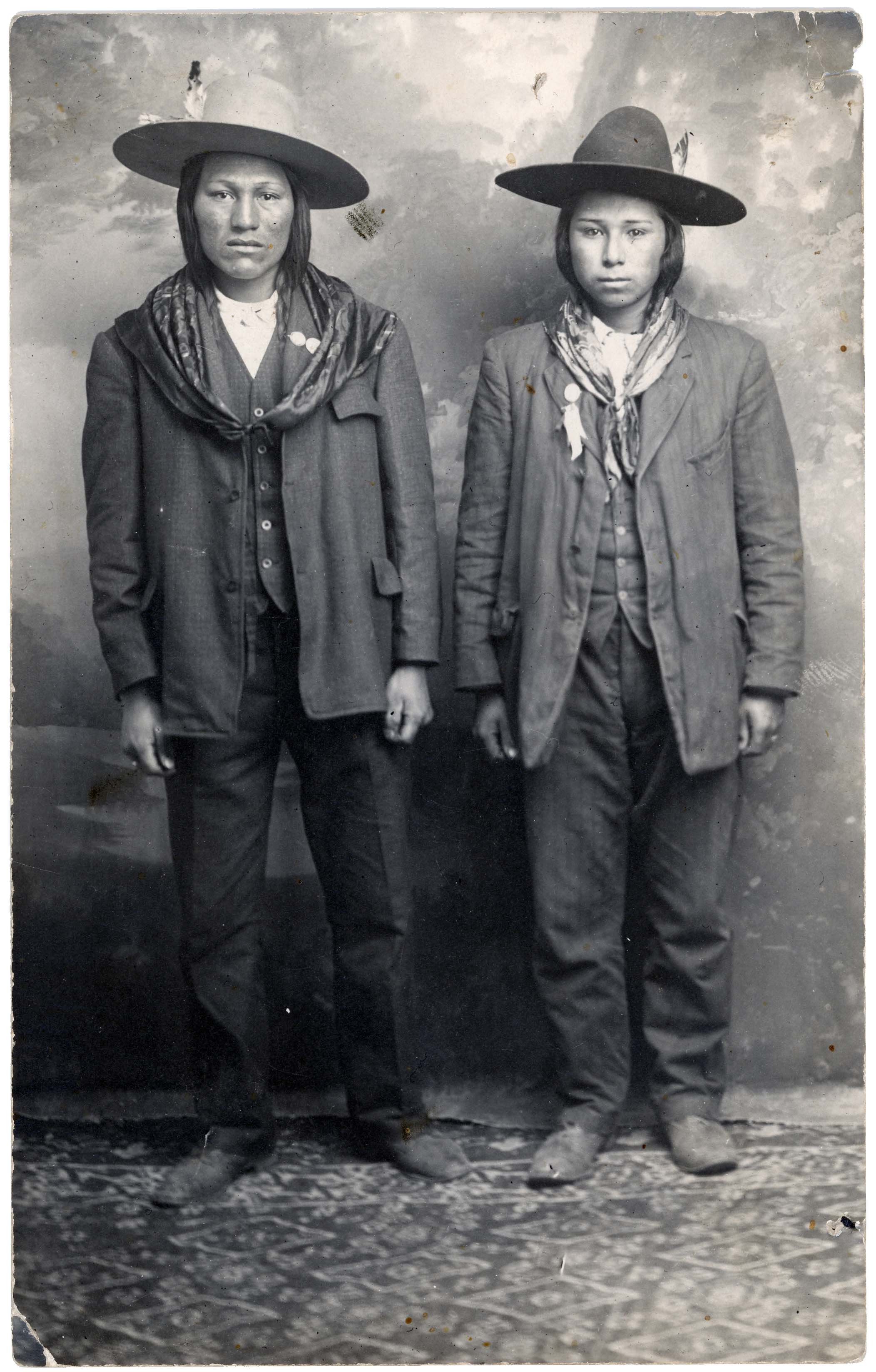 Two Native American men standing in hats and suits